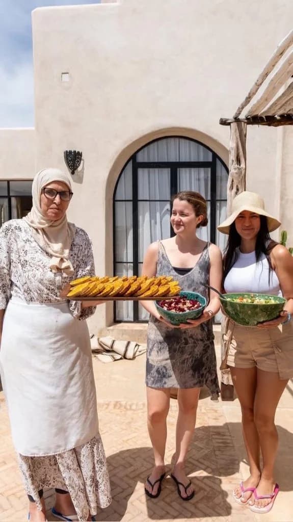 Voyageurs cuisinant avec une cheffe marocaine locale sur la terrasse d'une villa à Essaouira