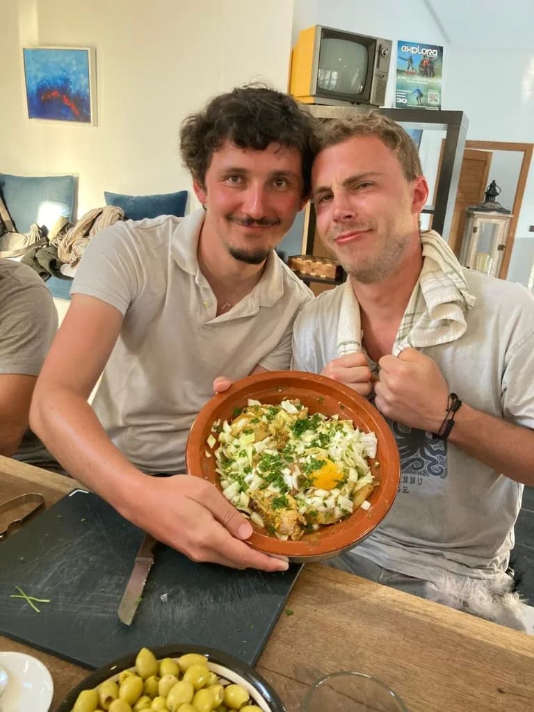 Voyageurs présentant un tajine marocain terminé pendant une expérience culinaire privée