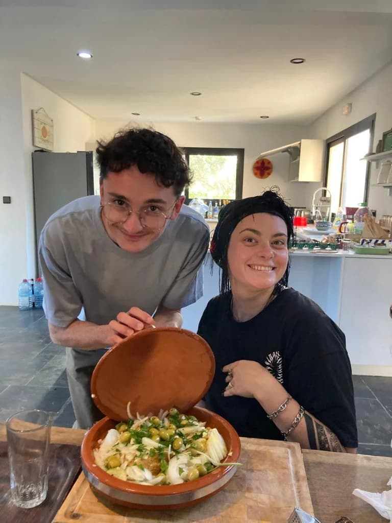 Voyageurs préparant un tajine marocain traditionnel pendant un cours de cuisine à Essaouira